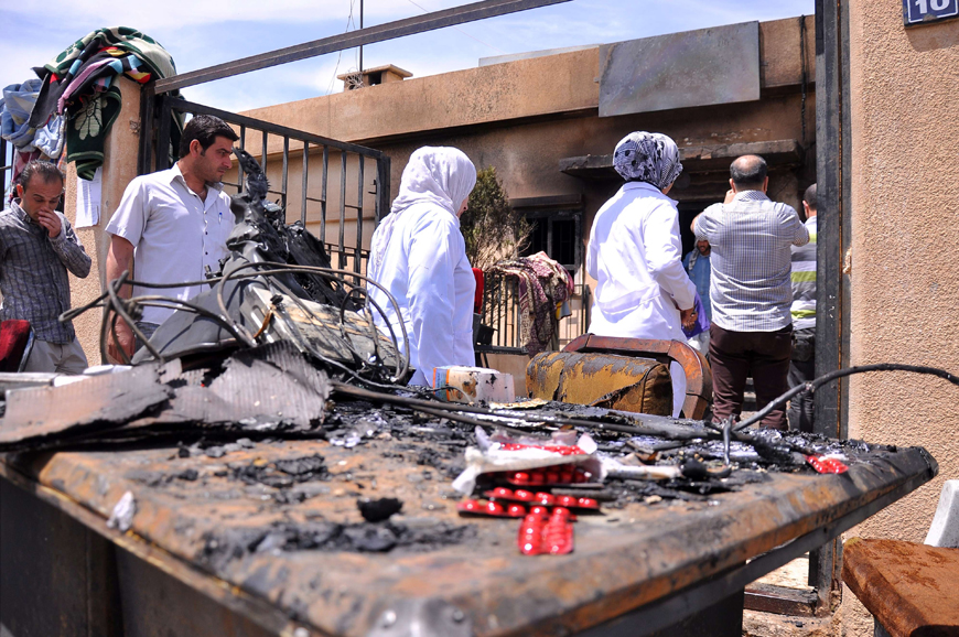 People inspect the damage in the Maysalun clinic where a fire broke out after a fuel tank exploded on Sunday (AFP photo)